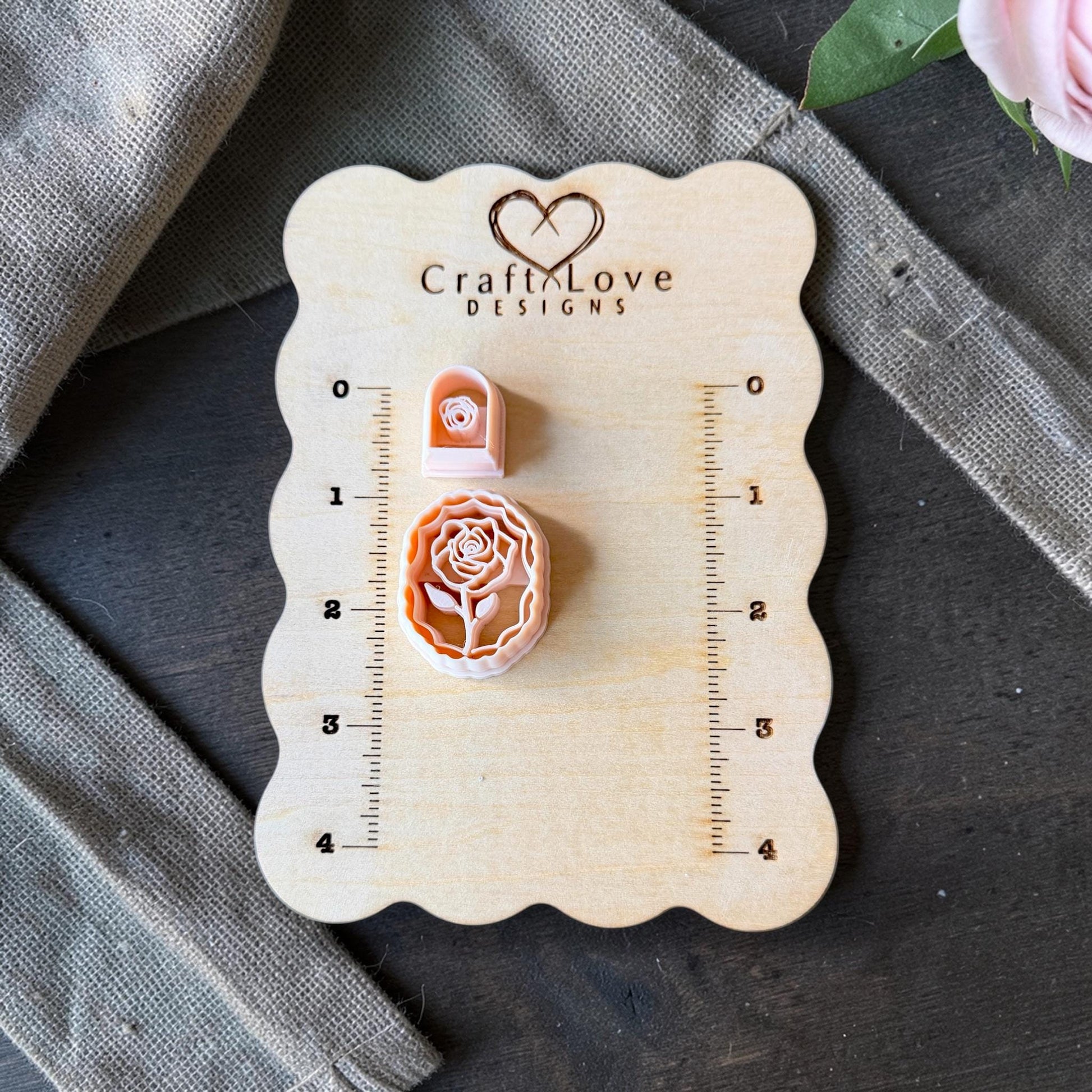 rose cameo cutter and small rose cutter on wooden sizing board