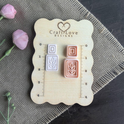 leaf rectangle cutter and square topper cutters with clay imprints on wooden sizing board
