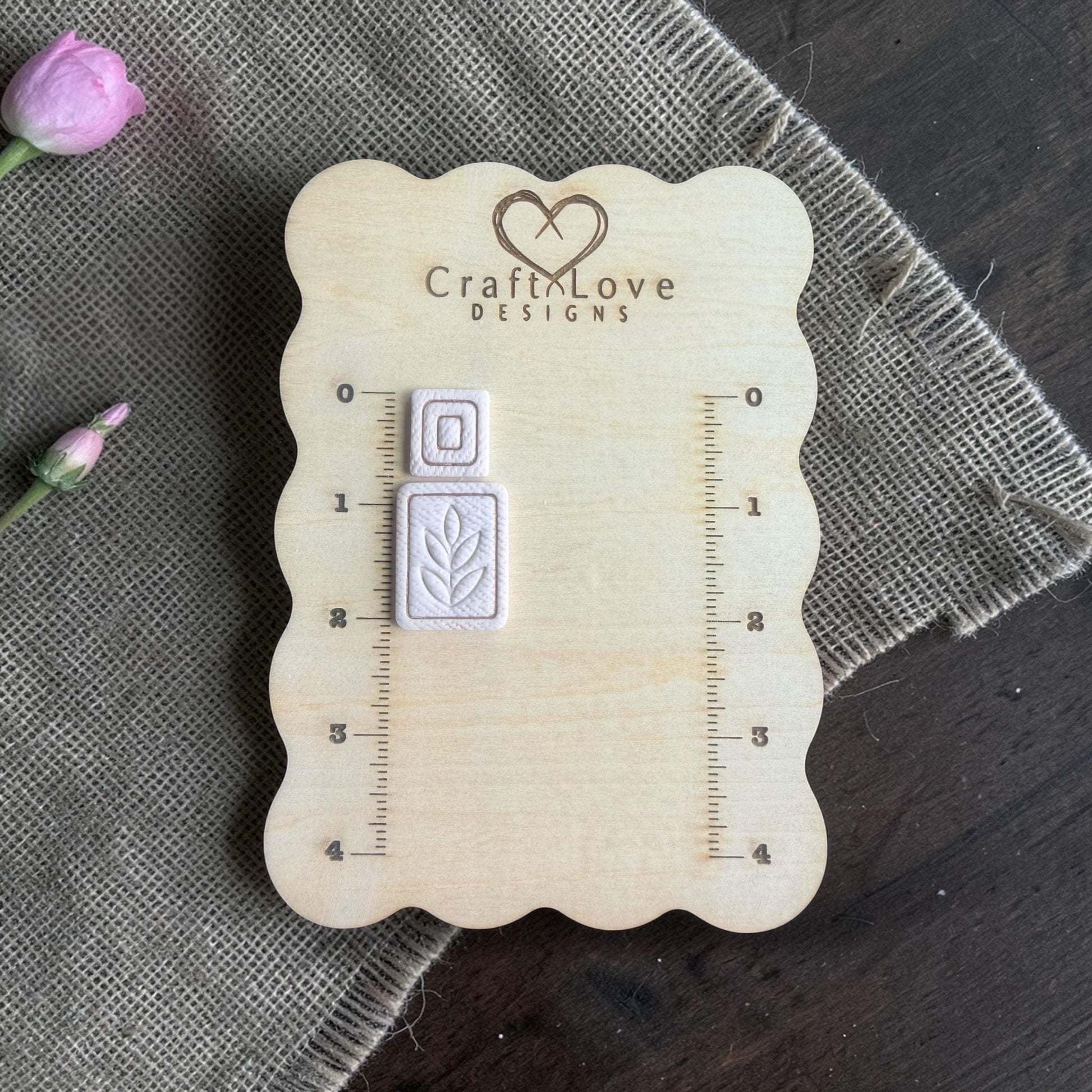 white clay imprints of square topper and leaf rectangle dangle on sizing board