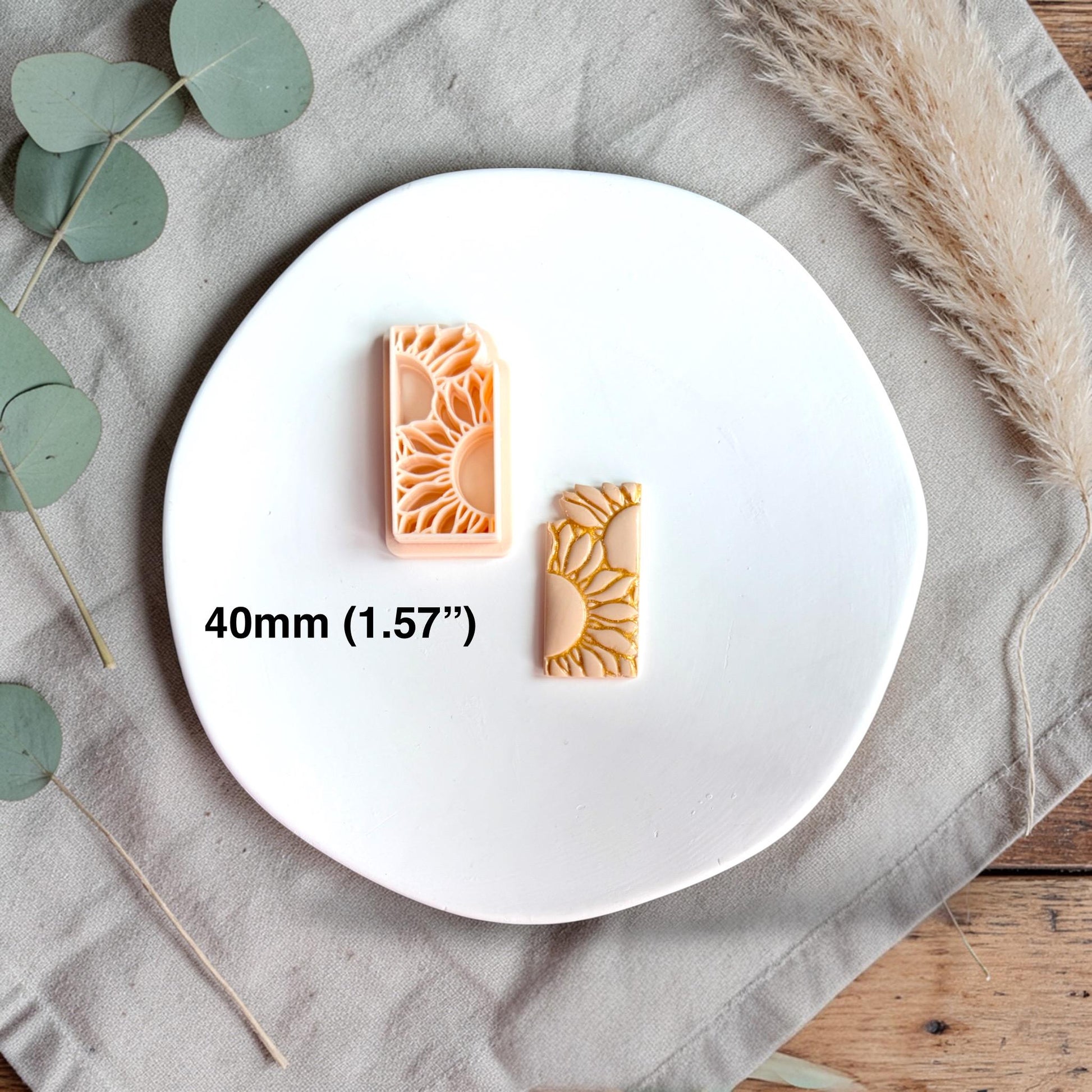 Sunflower polymer clay cutter and finished clay piece displayed on a white plate with size text showing 40mm.