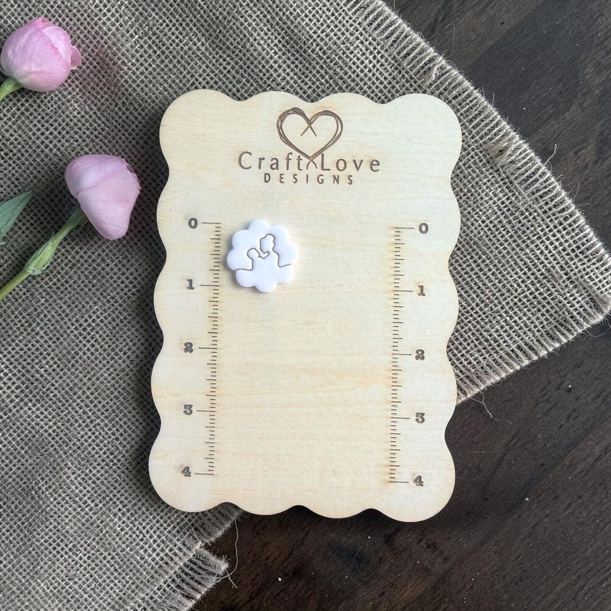 mom holding baby clay cutter on measurement board