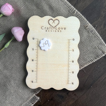 mom holding baby clay cutter on measurement board