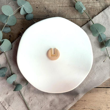 Round U cutout clay piece on white tray