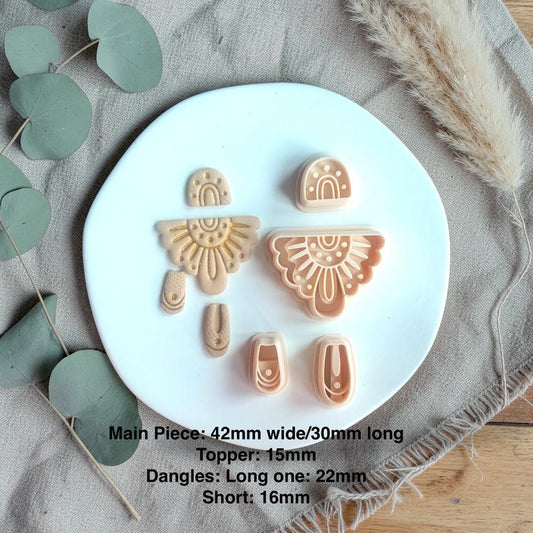 Cutter set shown with finished clay pieces including arch top, sunburst fan shape, and two dangling connector pieces with size details.