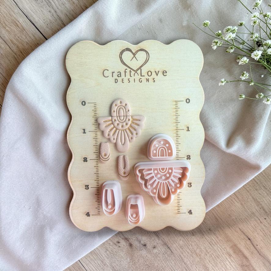 Full cutter set and finished pieces displayed on a wooden measuring board with ruler markings and brand logo.