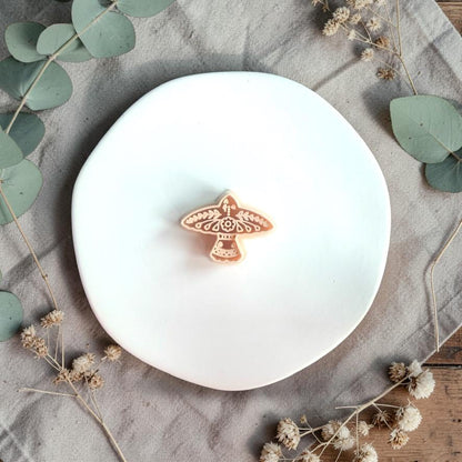 Polymer clay cutter showing bird shape with decorative folk pattern on a white plate with soft styling.