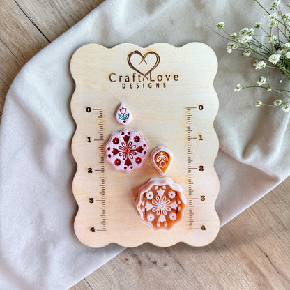 Mandala polymer clay cutter displayed on wooden measurement board with sizing grid