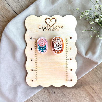 Oval floral polymer clay cutter displayed on measurement board showing size and scale