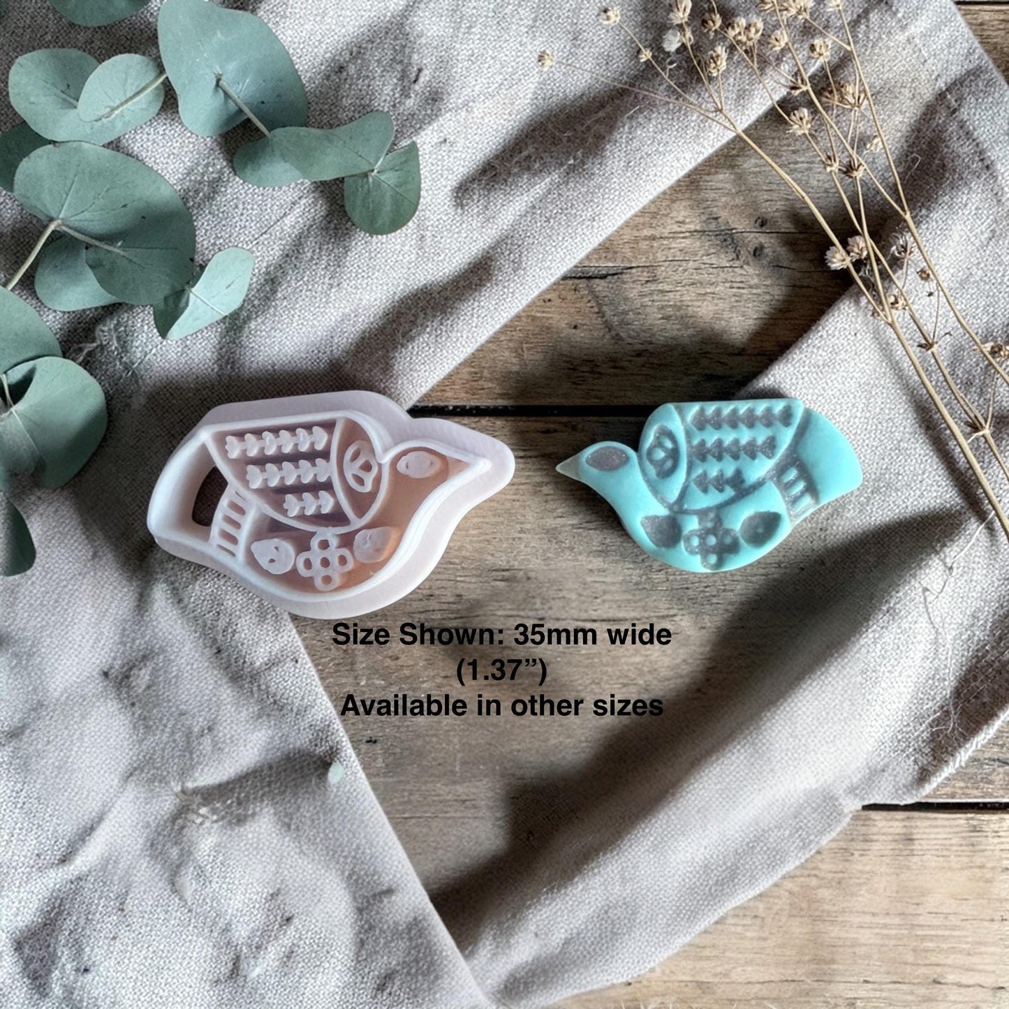 polymer clay cutter and finished turquoise folk bird charm showing embossed design
