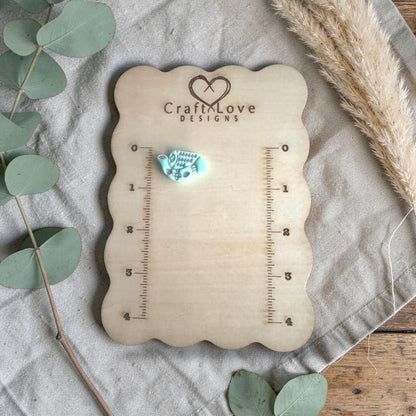 turquoise clay folk bird charm displayed on Craft Love Designs ruler board