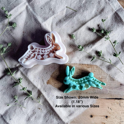rabbit clay cutter and finished turquoise rabbit charm with size text on linen