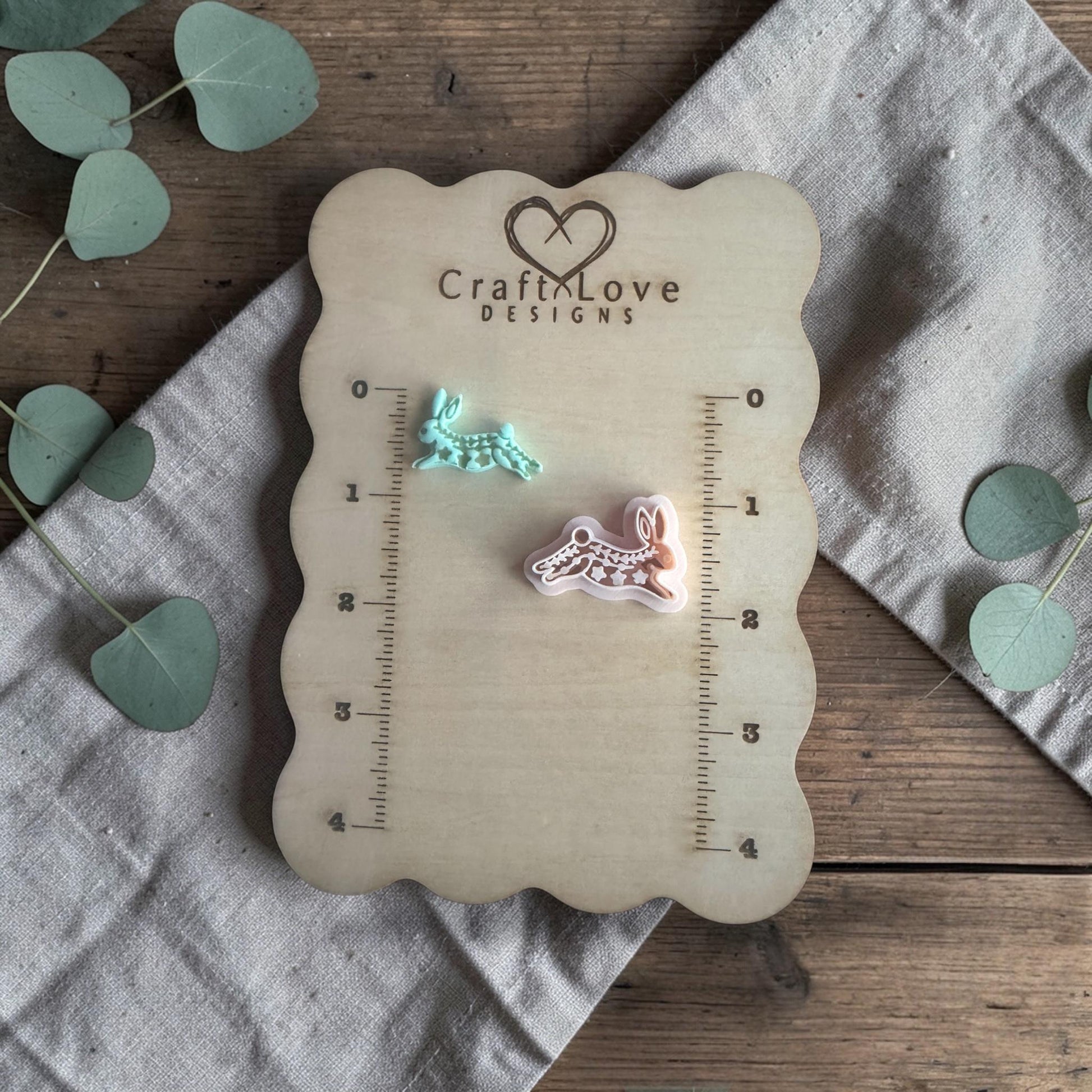 two clay rabbit charms on Craft Love Designs ruler board showing scale