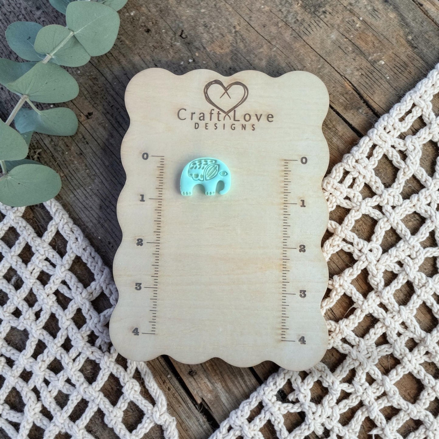 finished turquoise clay elephant charm displayed on Craft Love Designs ruler board