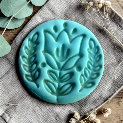 turquoise polymer clay charm with embossed Scandinavian tulip flower design