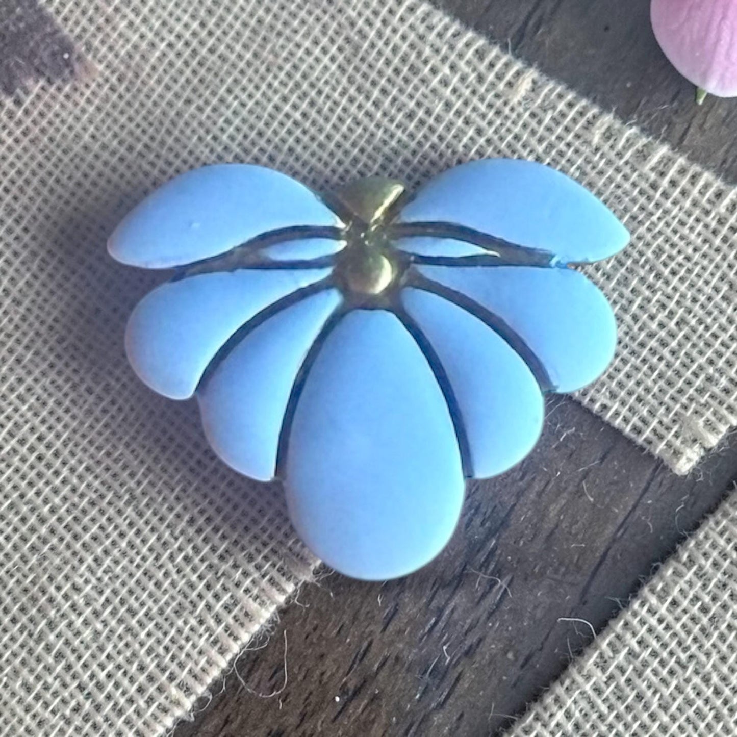 finished blue clay flower charm showing embossed petal lines