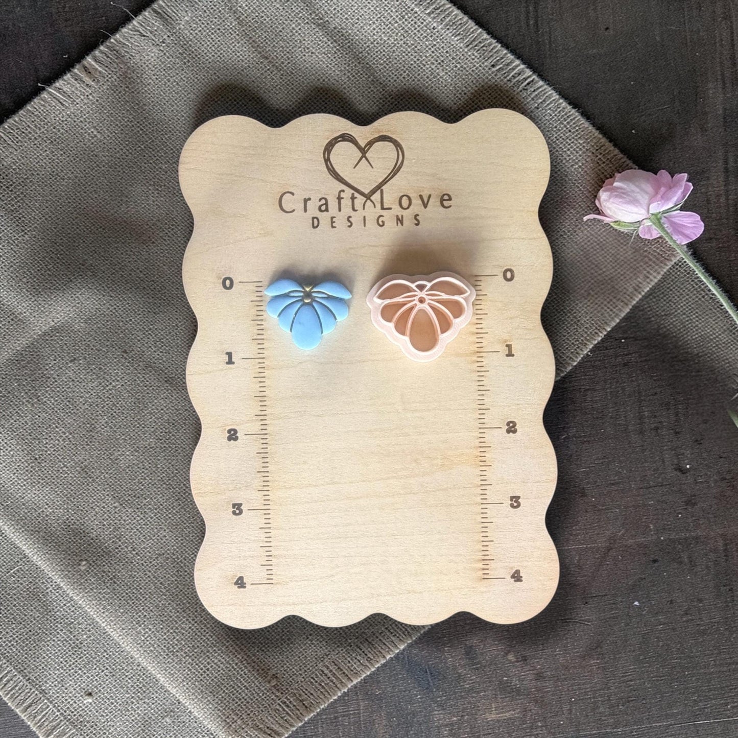 blue flower clay charm and cutter displayed on ruler board