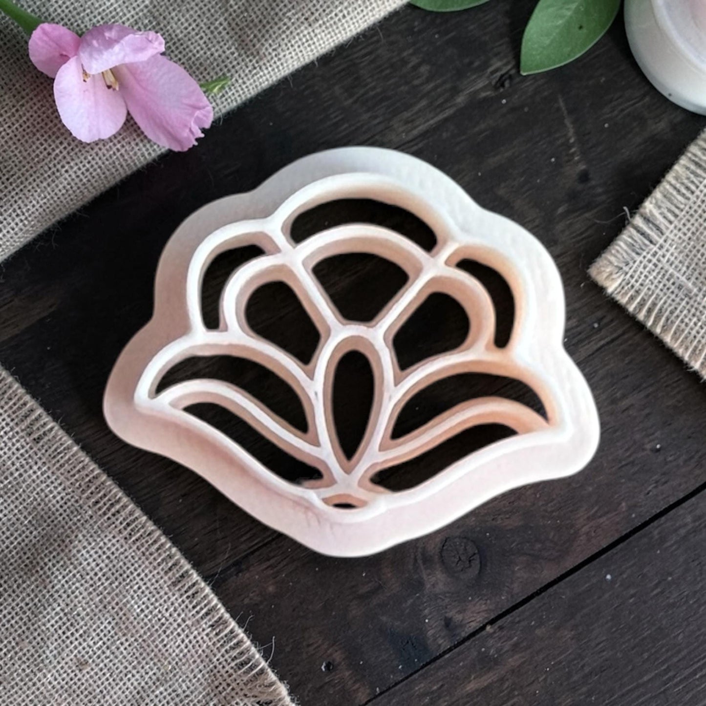 Close-up of the polymer clay cutter showing the internal petal lines that create the floral pattern.