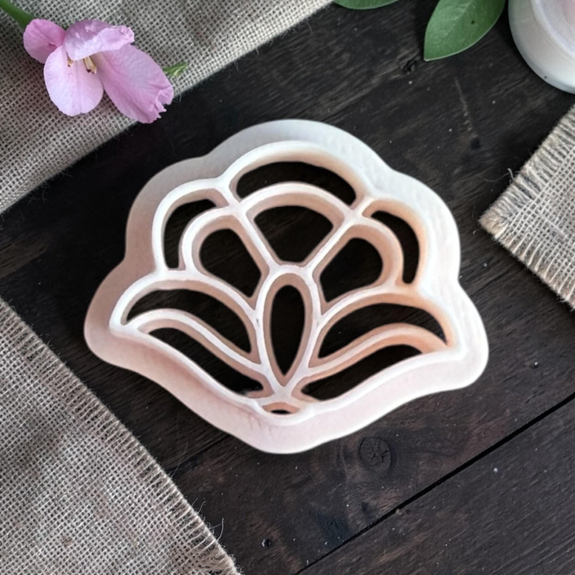 Close-up of the polymer clay cutter showing the internal petal lines that create the floral pattern.
