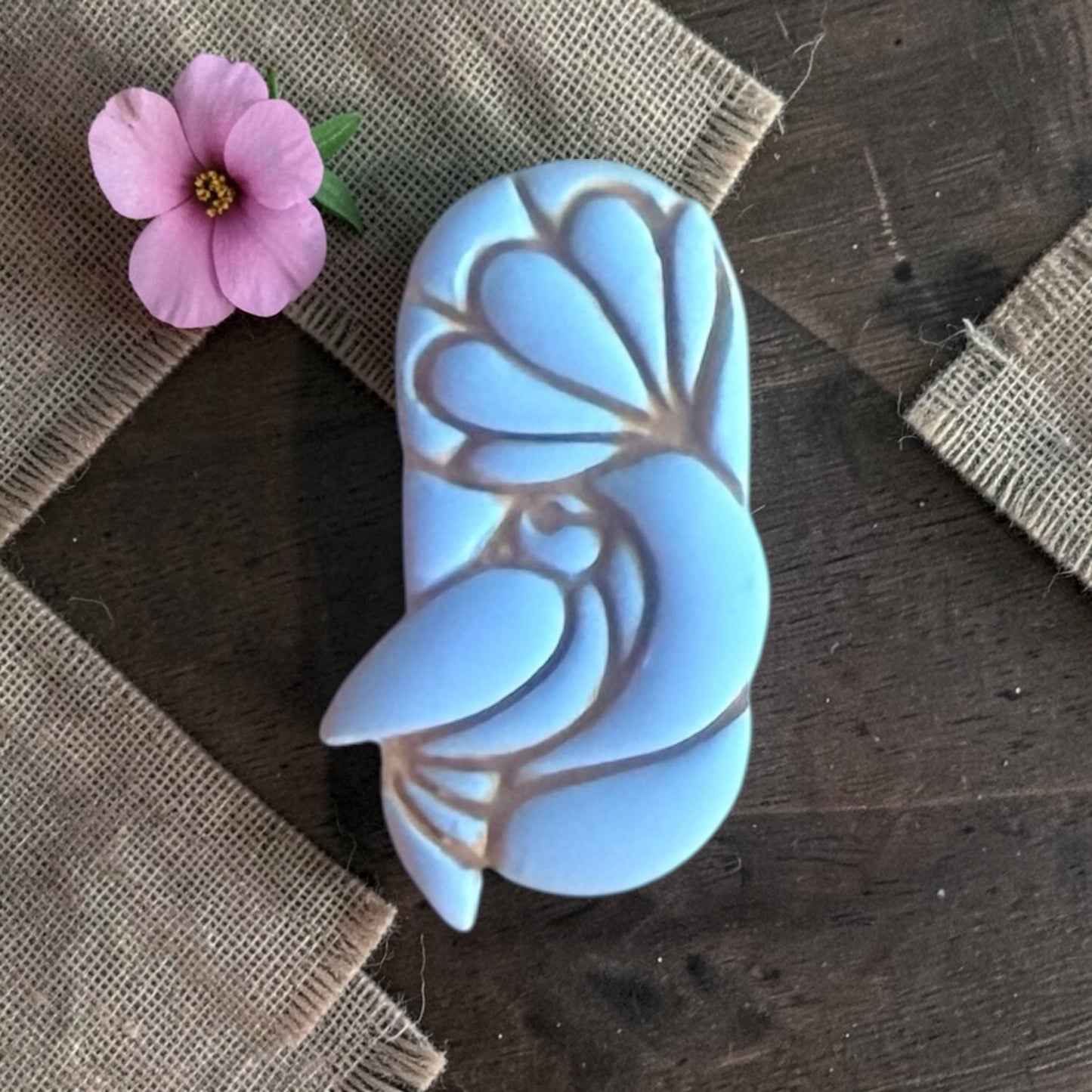 Close up of bird under flower clay piece.