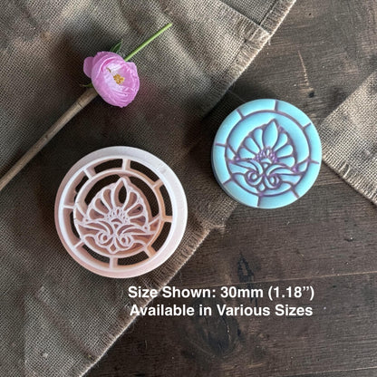 Floral clay cutter next to stained glass flower clay piece.