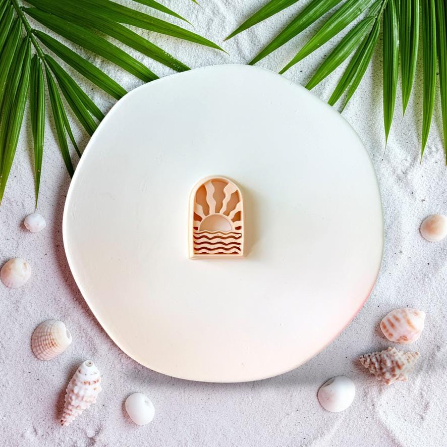 Ocean sunrise arch polymer clay cutter with wave design on sandy beach styled background