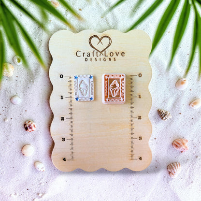 Seashell polymer clay cutter and earrings displayed on wooden sizing board with ruler