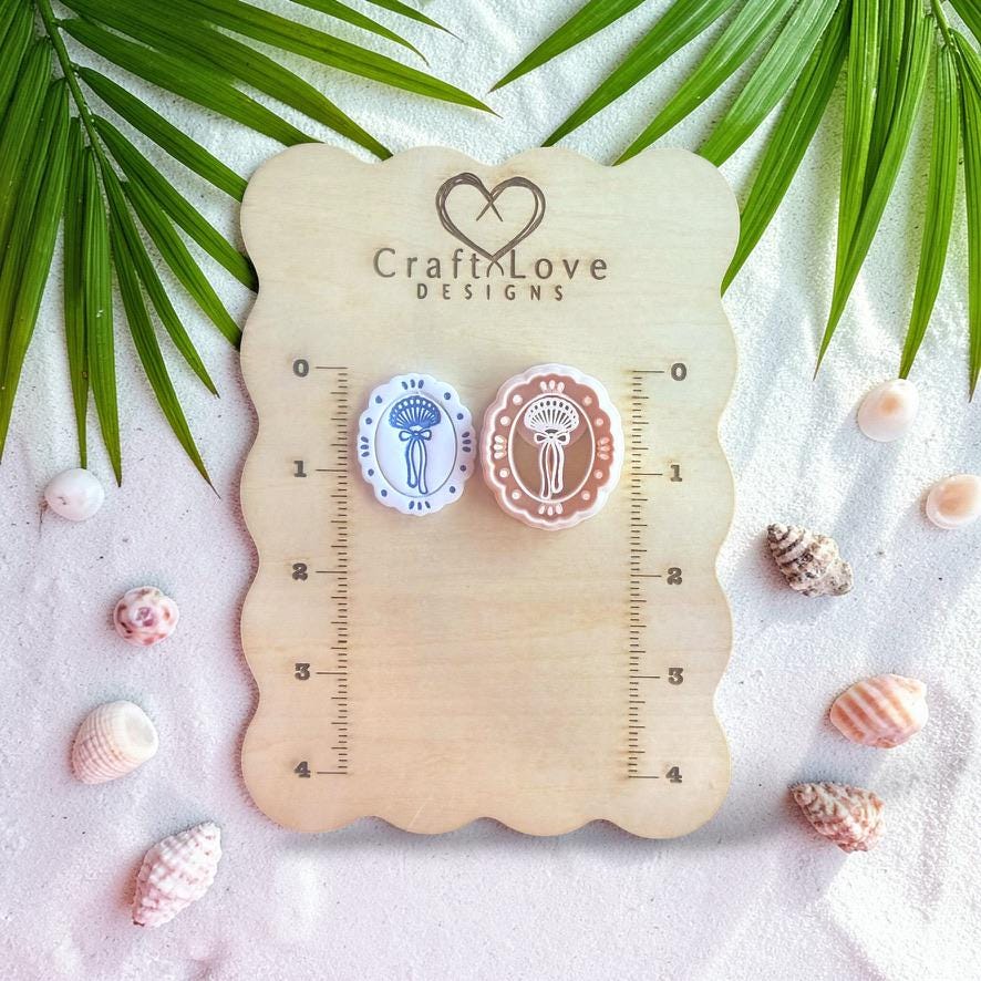 Seashell bow cutters displayed on wooden sizing board with ruler