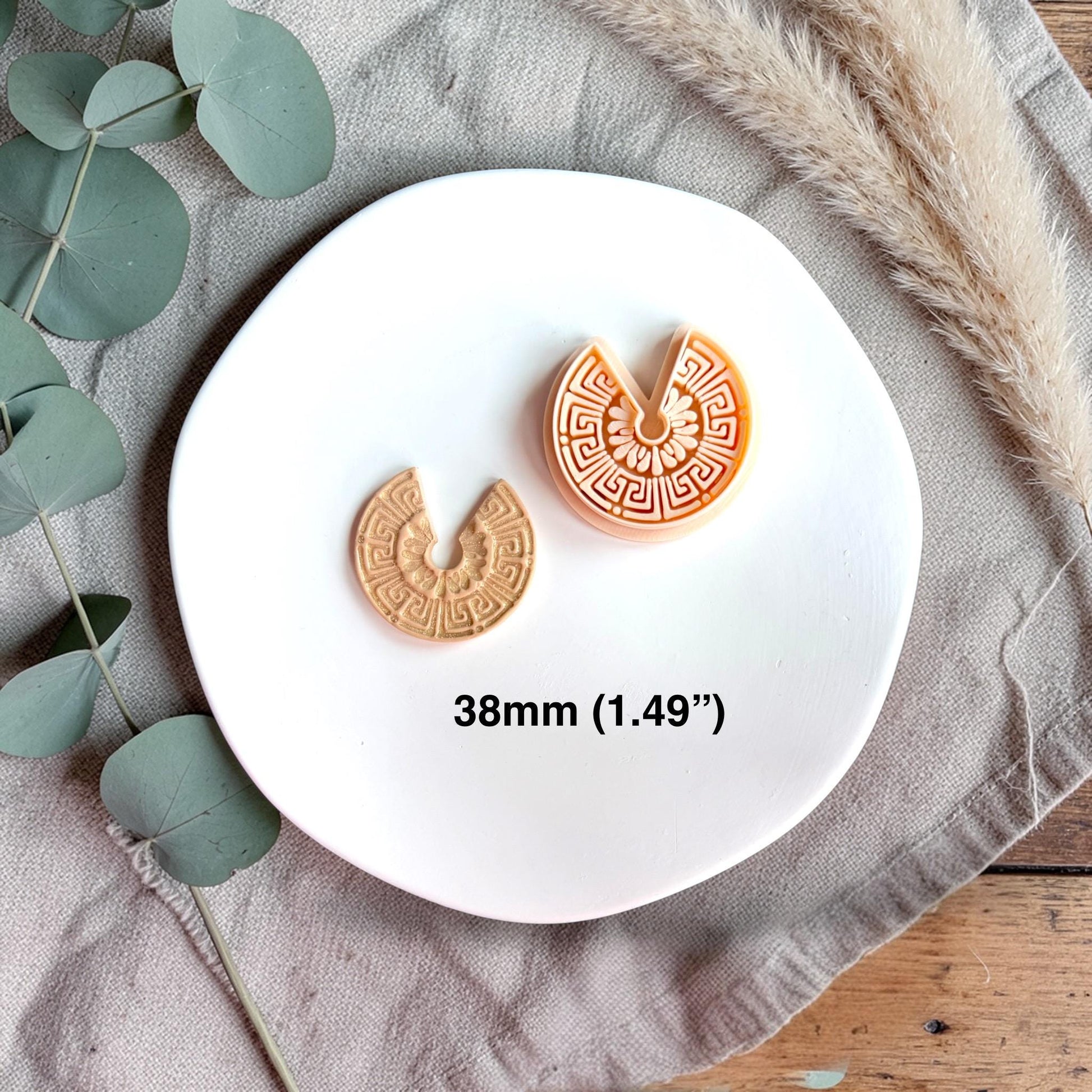 Polymer clay cutter and finished clay piece side by side with text showing size 38mm on a white plate.