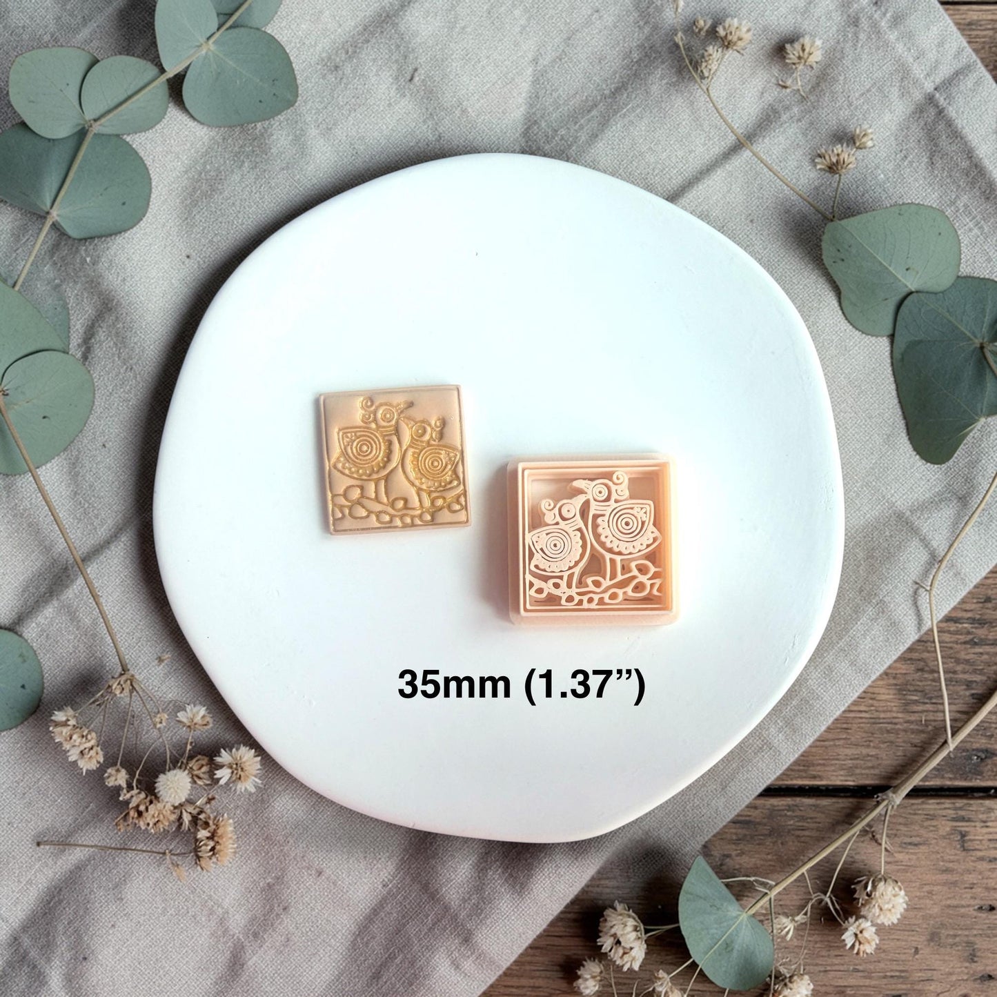 Polymer clay cutter and finished clay piece side by side with text showing size 35mm on a white plate.
