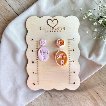 Flamingo and flower clay cutter set displayed on wooden measuring board with ruler for size reference.