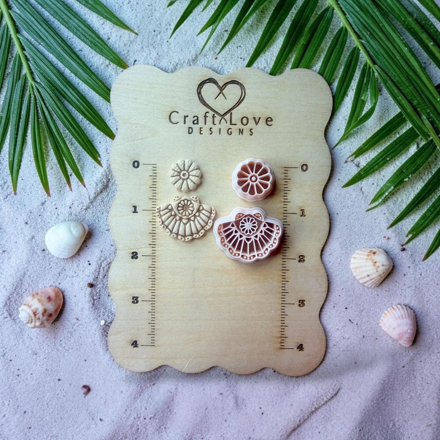 Fan shell polymer clay cutter with flower stud displayed on wooden board with coastal decor