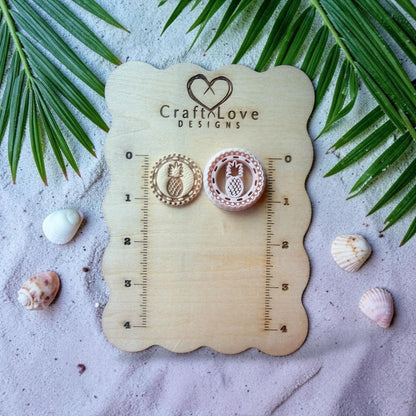 Pineapple polymer clay cutter displayed on beach styled background with sand and shells
