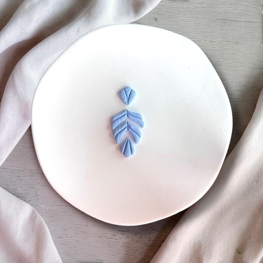 Finished blue clay earring using fern leaf cutter showing texture detail