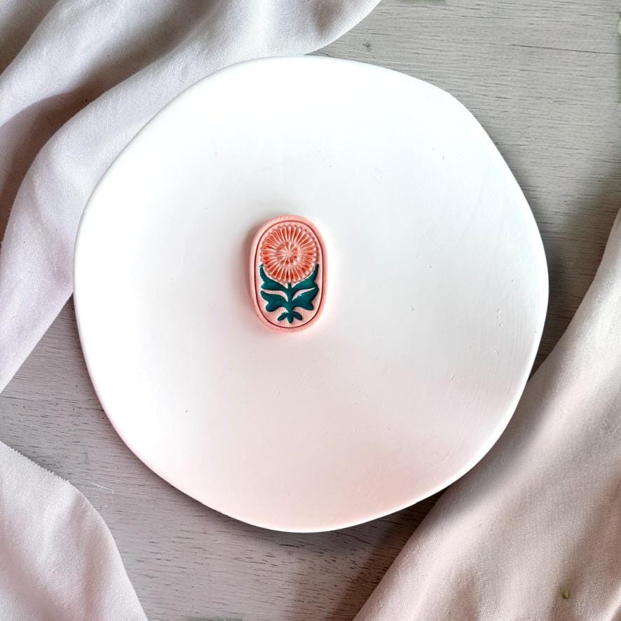 Finished clay piece using floral cutter showing stamped botanical design