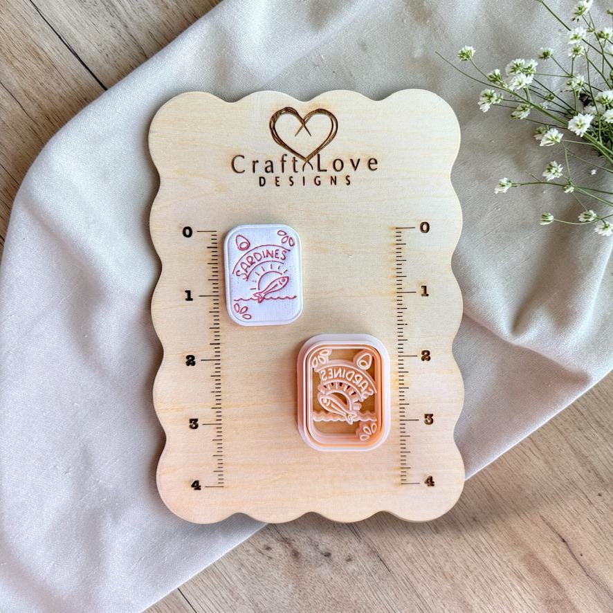 Sardine tin polymer clay cutter displayed on wooden sizing board
