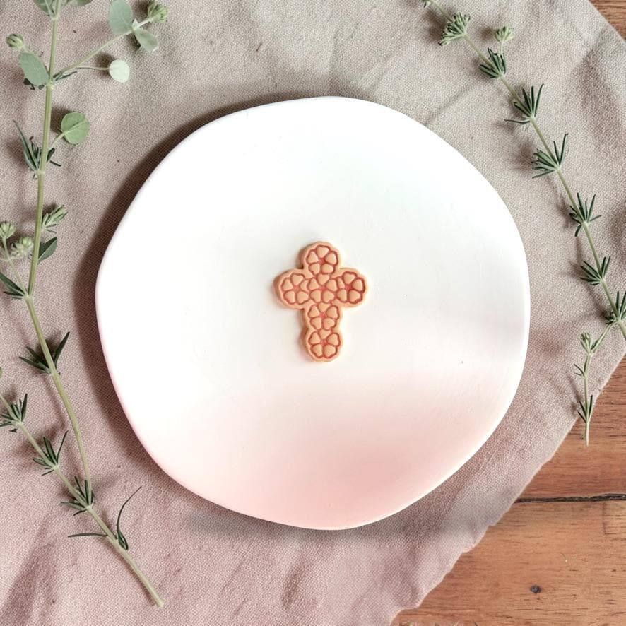 Floral cross clay closeup on white display plate