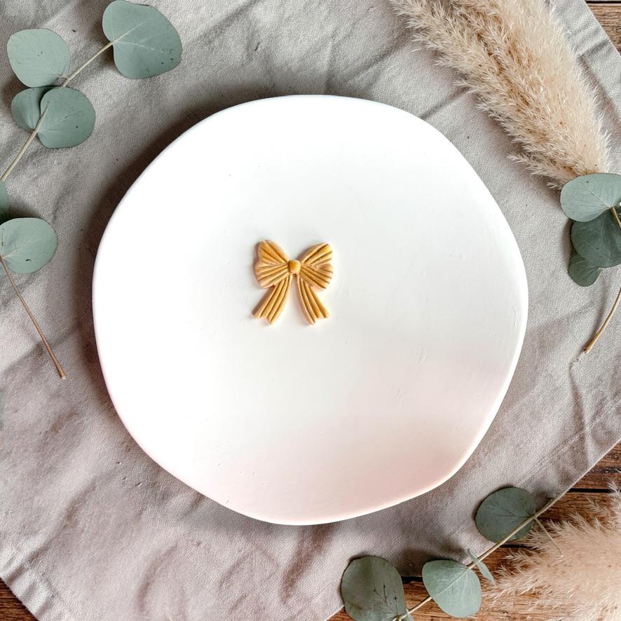 Finished bow clay piece displayed on white plate