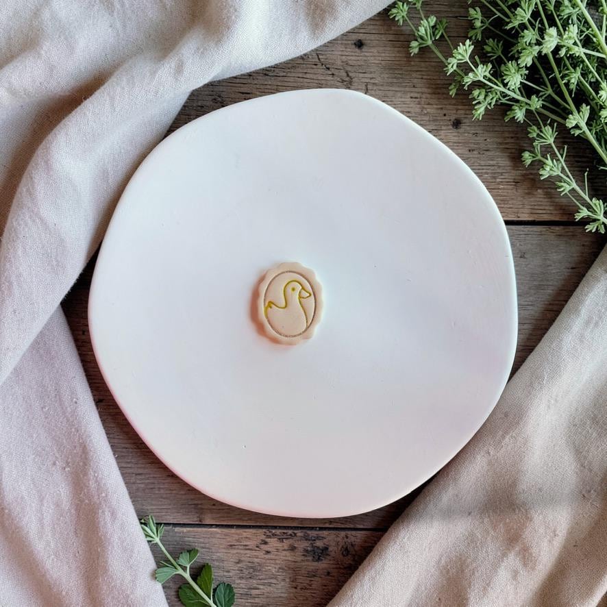 Duck cameo clay impression showing detailed silhouette on white plate