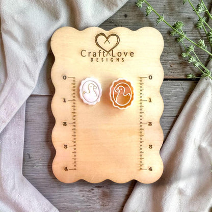 Duck cameo cutter and finished clay piece displayed on wooden measurement board