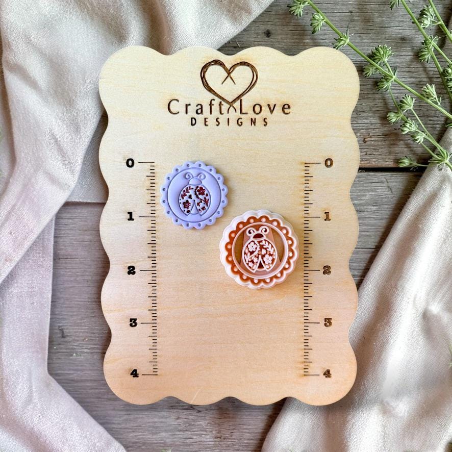 Ladybug polymer clay cutter and earrings displayed on wooden sizing board with ruler