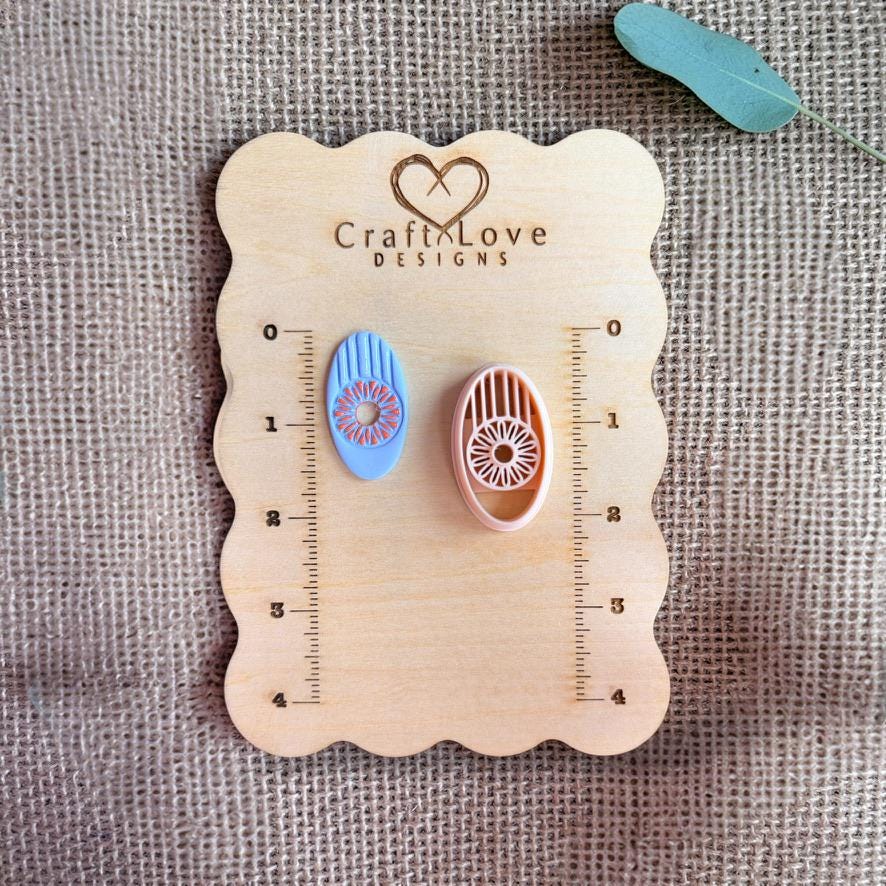 Oval sunburst cutter and finished clay piece shown on wooden measurement board
