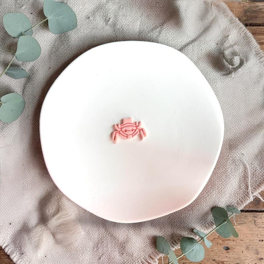 Finished crab clay piece with hat detail on white plate