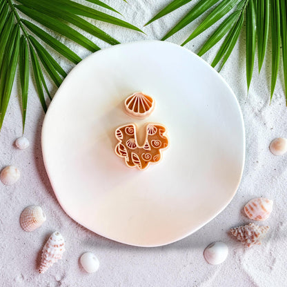 Polymer clay seashell arch earring cutter with textured shell pattern on beach styled background
