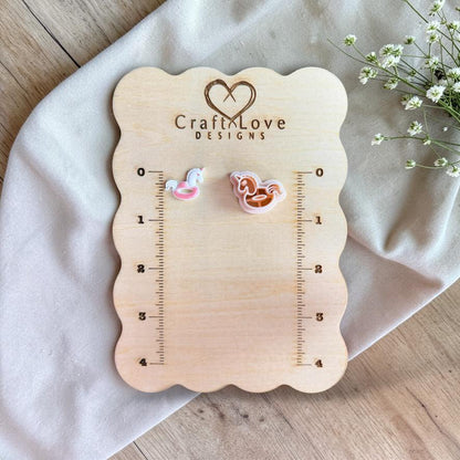Unicorn floatie cutter and finished clay piece displayed on wooden ruler board