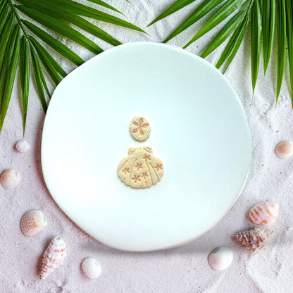 Finished clay earrings showing flower detailed shell with round daisy stud top