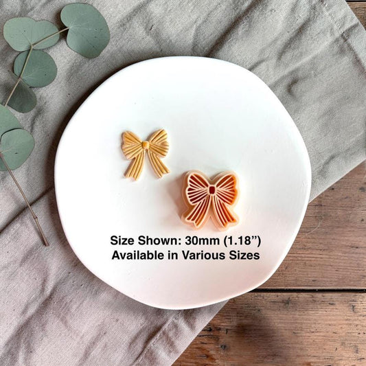 Bow clay cutter and finished piece with 30mm size reference on white plate