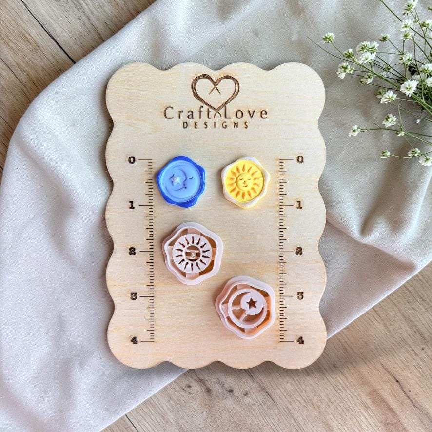 Sun and moon polymer clay cutters and clay samples displayed on wooden size board with ruler markings