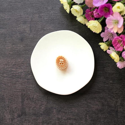 Oval cherry clay cutter with scalloped edge on white background