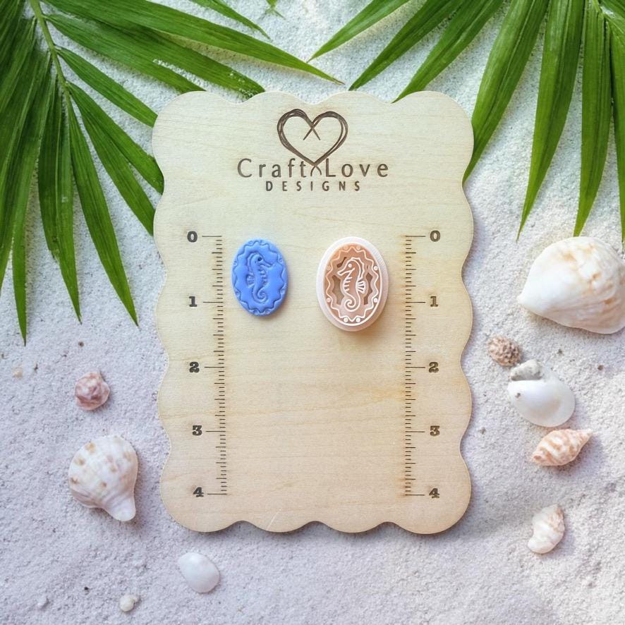 Seahorse clay piece and cutter displayed on wooden sizing board with seashells and tropical leaves