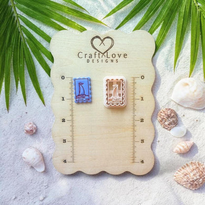 Sailboat frame clay cutter and finished pieces displayed on wooden sizing board with coastal decor